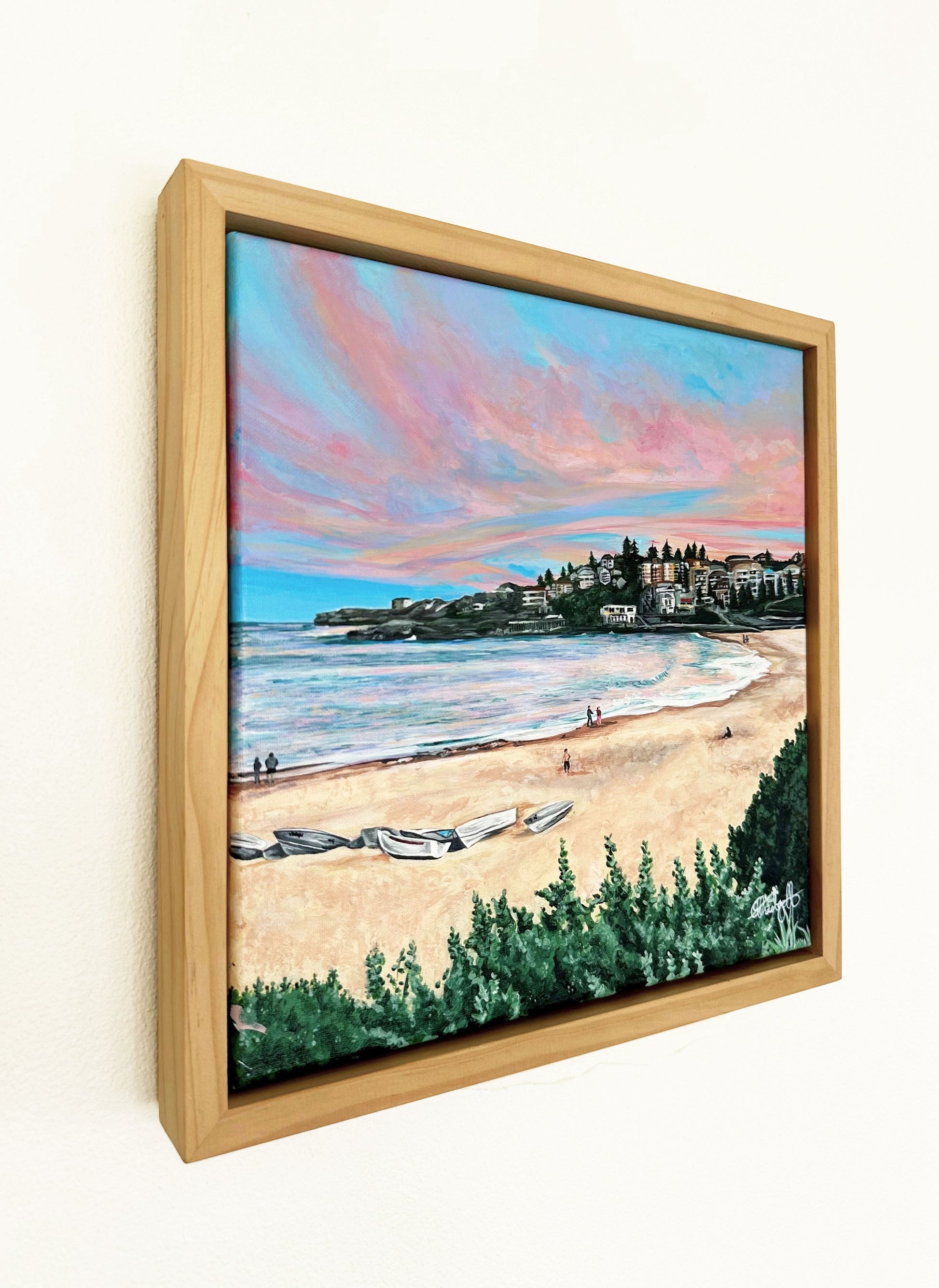 A fine art print of an original oil painting of Coogee Beach at dusk with pastel pink skies and calm waters, featuring greenery and a beach scene. One of the most iconic beaches in Sydney.